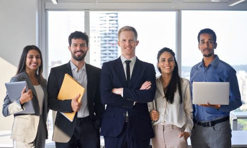 Young happy professional international team business people workers standing in corporate office, diverse multiethnic smiling employees colleagues company staff posing for team portrait together.